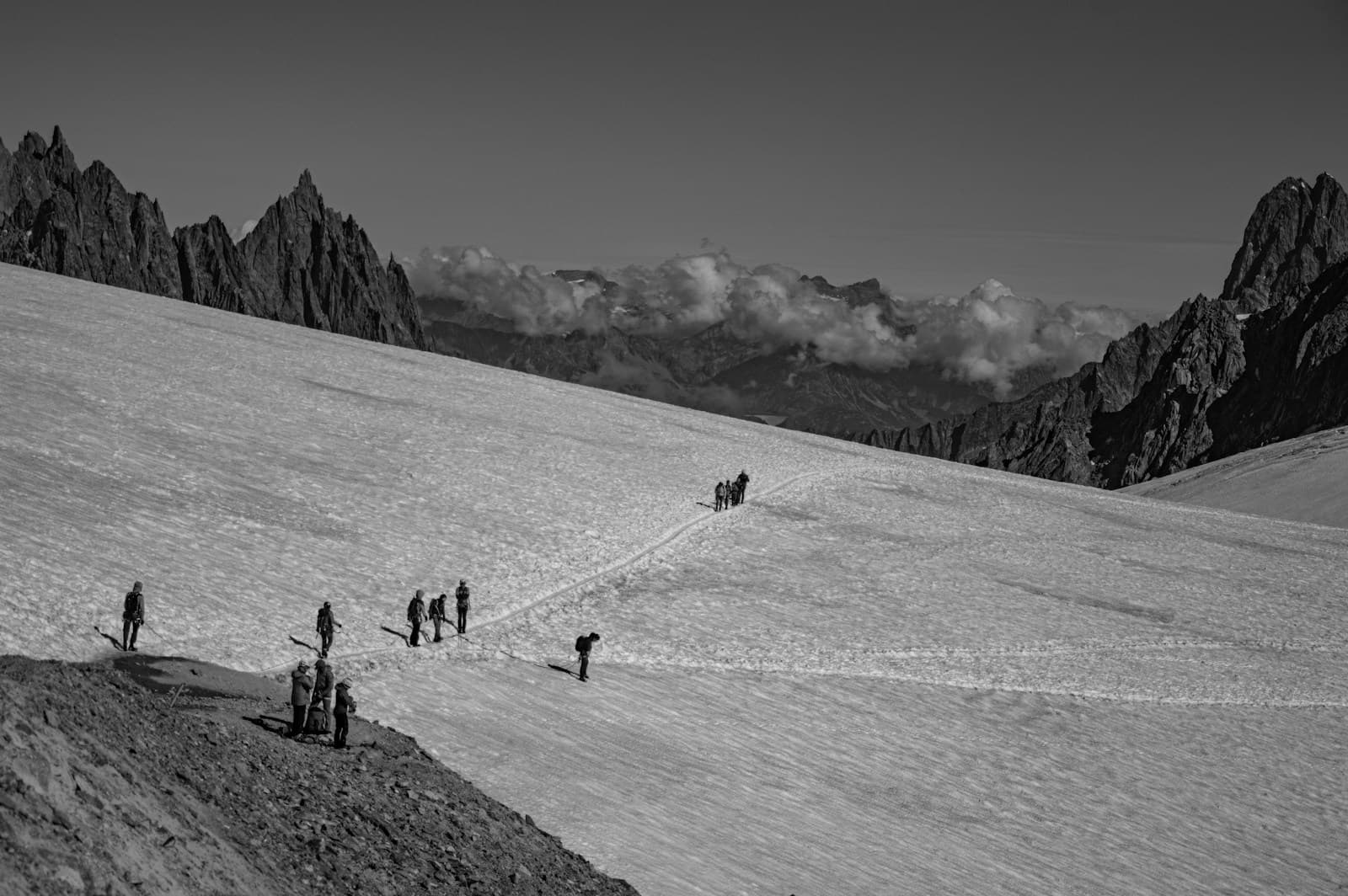 Hikers roped together crossing a glacier at dawn